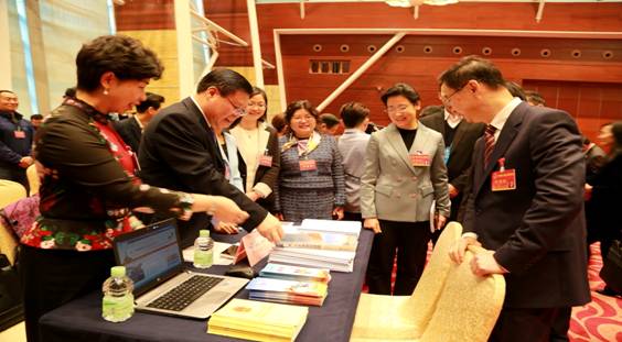 圖為市統(tǒng)計(jì)局工作人員為人大代表、政協(xié)委員做現(xiàn)場(chǎng)咨詢服務(wù)