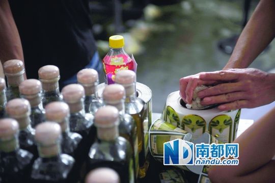 桌上堆著灌好的橄欖油與成卷的標簽貼紙。