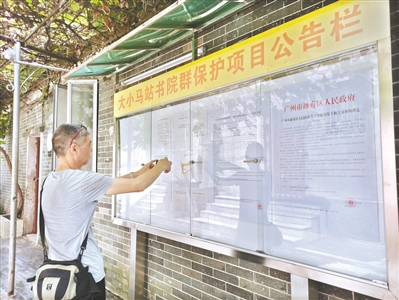 街坊通過公告欄詳細(xì)了解征收補(bǔ)償方案。