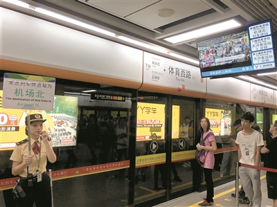 地鐵工作人員現(xiàn)場(chǎng)舉牌指引乘客乘坐貫通車(chē)