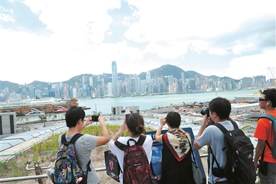 23日上午，首趟從廣州南站開往香港西九龍站的列車7時41分抵達。圖為抵達西九龍站的旅客在拍照。