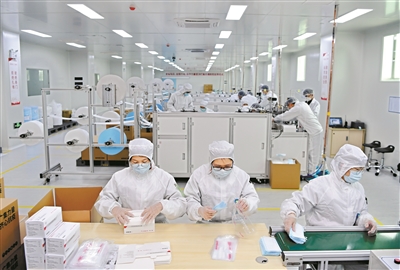 工人在流水線上，將生產(chǎn)好的口罩打包