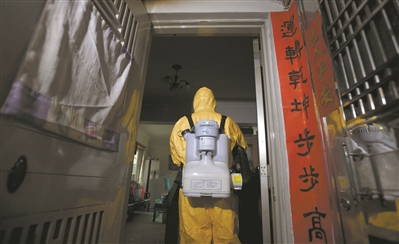 工作人員背著重達15公斤以上的機器，對確診病例屋里物品進行細致消毒。