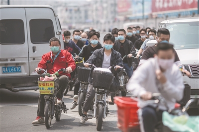 中大布匹市場附近，工人們戴著口罩返工。