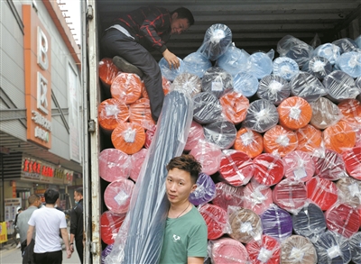 處于紡織商圈核心位置的廣州國際輕紡城，貨物裝滿車廂，工人忙著出貨。